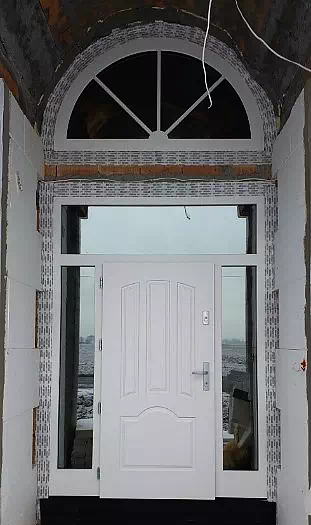 Widok elewacji domu z zamontowanymi drzwiami wzór 502,1 wymalowanymi w kolorze białe.