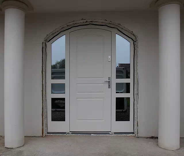 Widok elewacji domu z zamontowanymi drzwiami wzór 533,4B wymalowanymi w kolorze bałe.