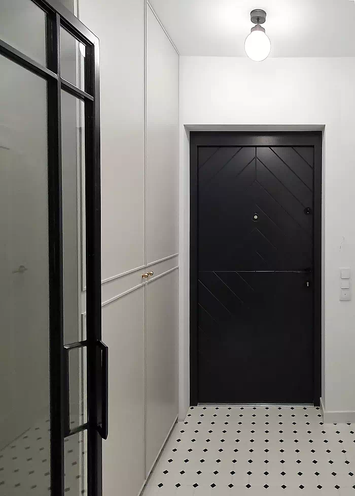 Widok elewacji domu z zamontowanymi drzwiami wzór 542,1W wymalowanymi w kolorze czarne.