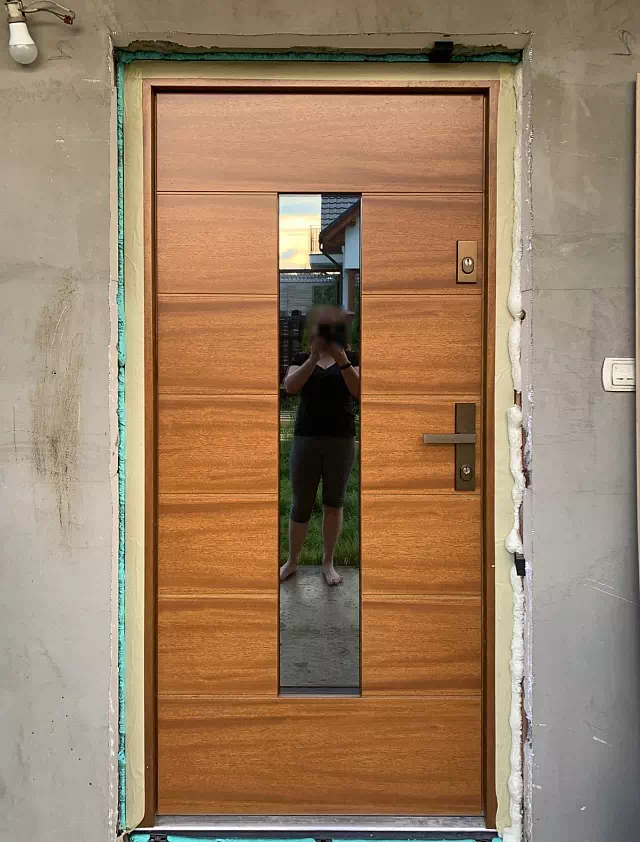 Widok elewacji domu z zamontowanymi drzwiami wzór 466,2 wymalowanymi w kolorze złoty dąb.