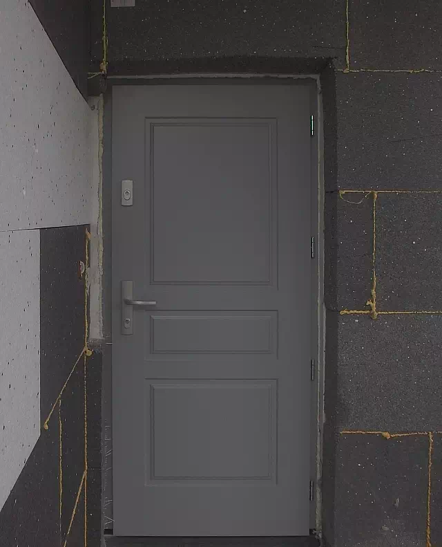 Widok elewacji domu z zamontowanymi drzwiami wzór 533,4 wymalowanymi w kolorze szare.