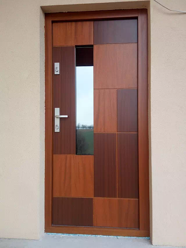 Widok elewacji domu z zamontowanymi drzwiami wzór 416,12 wymalowanymi w kolorze złoty dąb + orzech.
