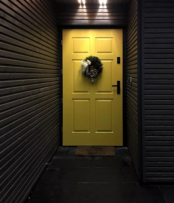 Widok elewacji domu z zamontowanymi drzwiami wzór 533,10 wymalowanymi w kolorze zółte+antracyt.